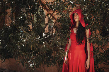 Frau mit Rotkäppchen-Kostüm durch Pflanzen - MRRF01500