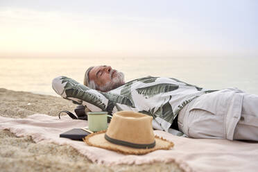 Mature man sleeping at beach - VEGF04967