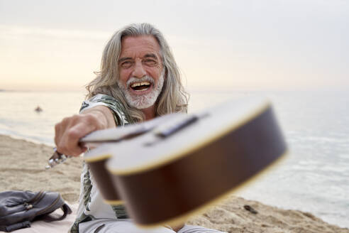 Lachender Mann mit Ukulele am Strand - VEGF04979
