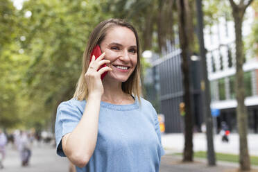 Glückliche blonde Geschäftsfrau im Gespräch mit einem Smartphone - PNAF02271