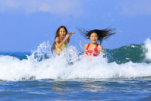 Female friends enjoying in water during sunny day - EAF00132