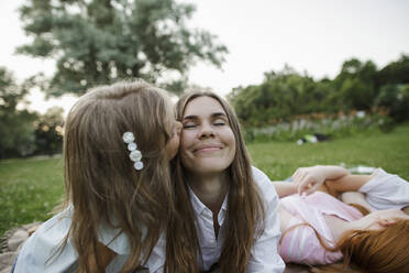 Girl kissing mother at public park - LLUF00057