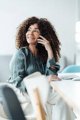 Female professional talking on smart phone in office - JOSEF05582