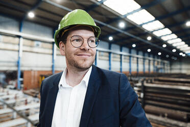 Lächelnder Geschäftsmann mit Schutzhelm in der Metallindustrie - JOSEF05722