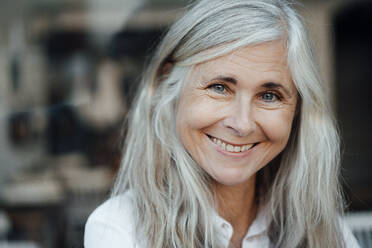 Lächelnde reife Frau mit grauen Haaren im Cafe - JOSEF05777