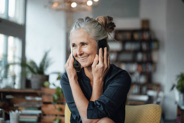 Smiling businesswoman talking on mobile phones at cafe - JOSEF05813