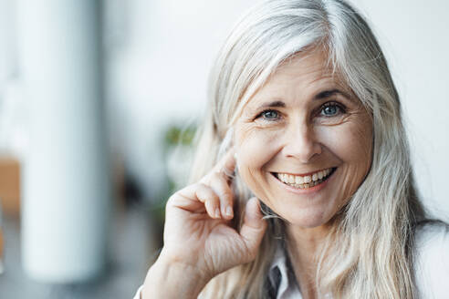 Happy mature woman with gray hair in cafe - JOSEF05825