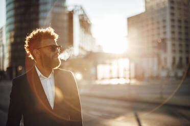 Männlicher Freiberufler mit Sonnenbrille auf der Straße stehend - GUSF06348