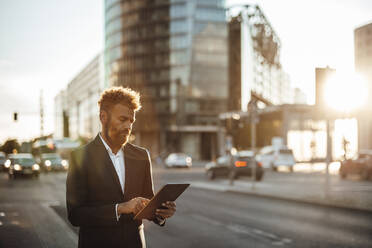 Mature businessman using digital tablet on street - GUSF06350