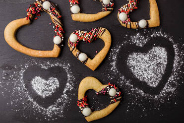 Studio shot of heart shaped cookies flat laid against black background - FLMF00662