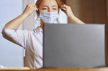 Krankenschwester mit Gesichtsmaske bei der Online-Beratung - AZF00348