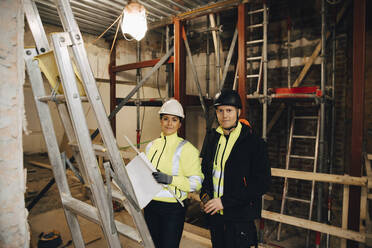 Portrait of male construction worker standing with female worker at site - MASF25135