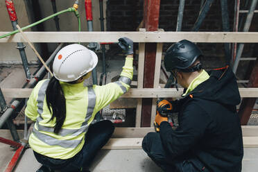 Male and female colleagues working together at construction site - MASF25141