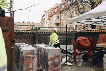 Bauunternehmerin im Gespräch mit einem männlichen Arbeiter auf der Baustelle - MASF25153