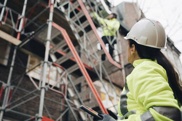 Bauunternehmerin mit Schutzhelm bei der Untersuchung einer Baustelle - MASF25155