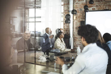 Männliche und weibliche Fachkräfte diskutieren über die Präsentation im Büro - MASF25305