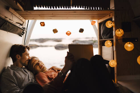 Male friends using laptop in camping van at evening - MASF25314