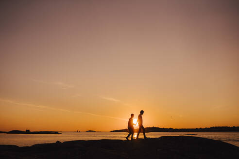 Homosexuelles Paar verbringt seine Freizeit bei einem Spaziergang während des Sonnenuntergangs - MASF25341