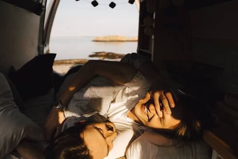 Homosexuelles Paar entspannt sich im Wohnmobil während des Sommerurlaubs - MASF25373