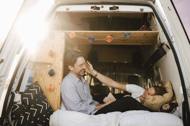 Glückliches schwules Paar verbringt seine Freizeit im Campingbus während des Urlaubs - MASF25378
