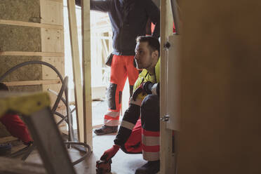 Männlicher Bauarbeiter, der auf einer Baustelle mit einem Laserwerkzeug arbeitet - MASF25437