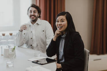 Smiling male and female colleagues at education class - MASF25459