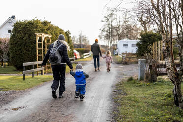 Rückansicht in voller Länge von Mutter und Sohn, die sich beim Gehen auf der Straße an den Händen halten - MASF25530