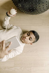 Unmittelbar über der Aufnahme eines Jungen, der zu Hause ein Selfie mit seinem Smartphone macht - MASF25566