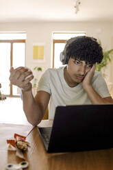 Male teenager using laptop while sitting at home - MASF25602