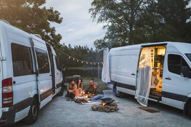 Female and male friends talking while spending leisure during camping - MASF25632