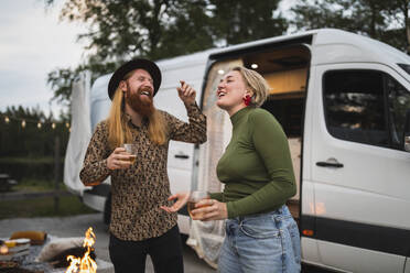 Glückliches junges Paar tanzt abends am Campingwagen - MASF25643