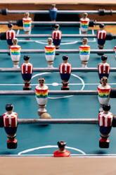 Detailaufnahme eines Retro-Tischfußballs mit hölzernen Miniaturfiguren von Spielern auf Metallstangen - ADSF29974