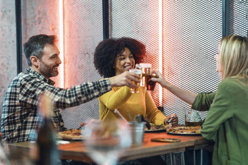 Glückliche männliche und weibliche Freunde stoßen in einem Restaurant an - JSRF01590