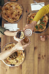 Male and female friends raising toasts in restaurant - JSRF01591