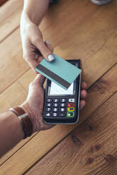 Woman paying through credit card in restaurant - JSRF01596