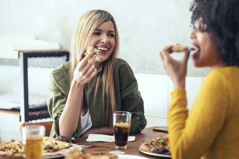 Weibliche Freunde essen Pizza im Restaurant - JSRF01605