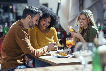 Männliche und weibliche Freunde benutzen Handys im Restaurant - JSRF01609