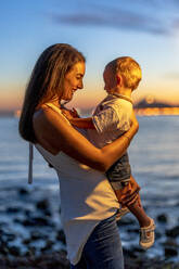 Smiling mother looking at son during sunset - DLTSF02173
