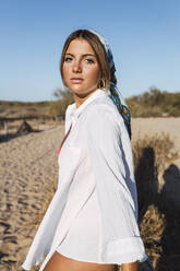 Schöne junge Frau am Strand stehend an einem sonnigen Tag - JRVF01777
