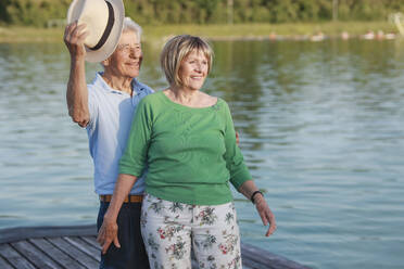 Lächelndes älteres Paar, das zusammen auf einem Steg steht - AANF00030