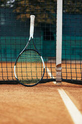 Racket on tennis court net - OYF00487