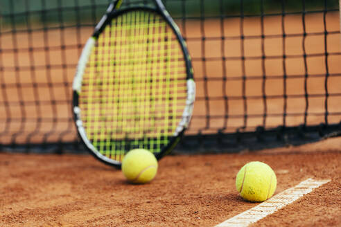 Tennisschläger und Ball auf dem Sportplatz - OYF00490