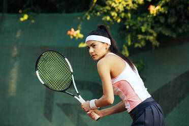 Eine Tennisspielerin hält einen Schläger, während sie auf einem Sportplatz steht - OYF00501