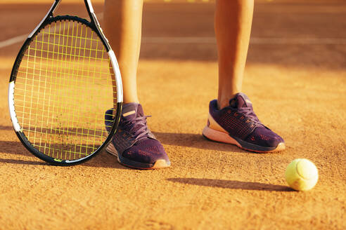 Tennisspielerin mit Schläger und Ball auf einem Sportplatz - OYF00516