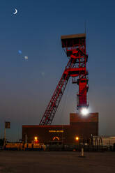 Germany, North Rhine-Westphalia, Huckelhoven, Crescent moon shining over Zeche Sophia-Jacoba shaft tower at night - FRF00938