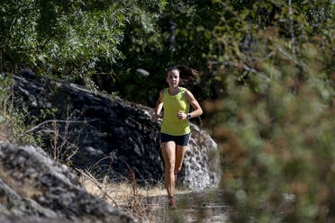 Sportswoman running in forest - OCMF02216