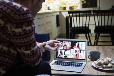 Young man talking with family through video conference during Christmas - ABIF01621