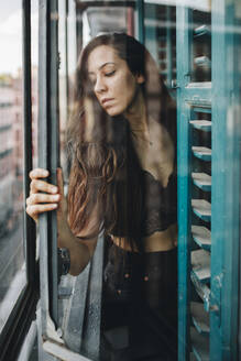 Einsame Frau hält Glasfenster - MRRF01515