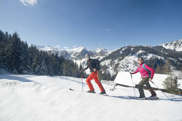 Junger Mann und Frau beim Skifahren im Schnee - HHF05681