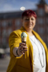 Mature woman giving ice cream cone - OCMF02231